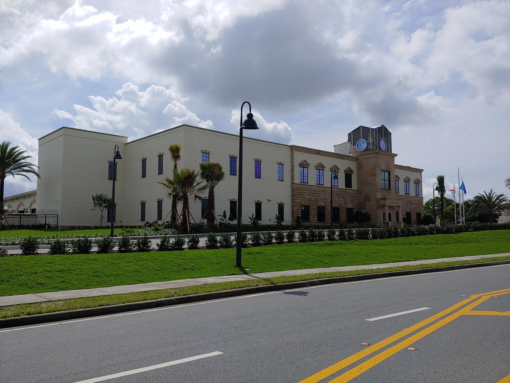 Front side view of large building with clouds in background