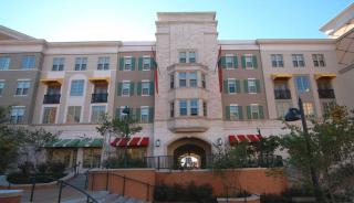 Front of Washington University Umrath house. Grey brick building with windows and green shutters. 