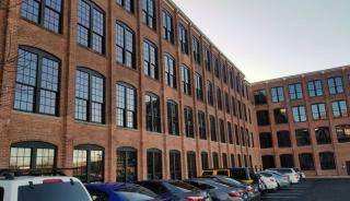 Side of historic brick building with large windows