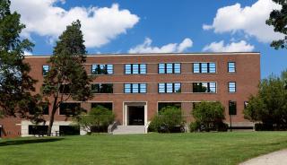 Exterior of brick building with windows and trees in the front 