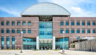 Front view of a building with a grand entrance and a significant glass window, highlighting its architectural elegance.